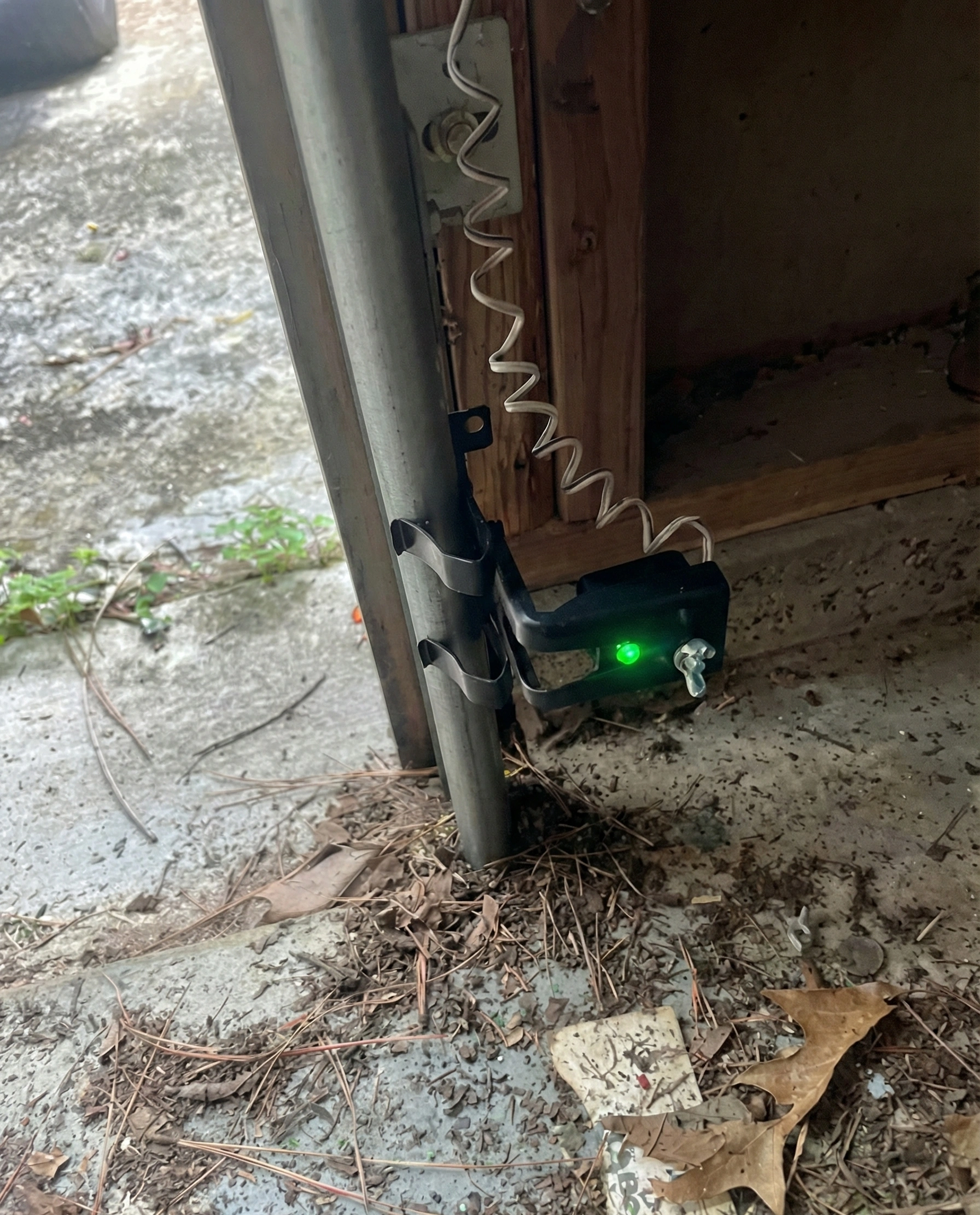 Garage door safety sensor with solid green LED light indicating proper alignment